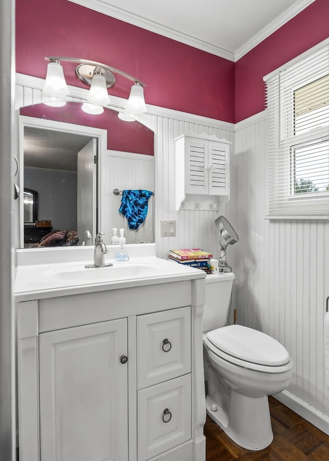 bathroom featuring parquet flooring, toilet, wooden walls, vanity, and ornamental molding