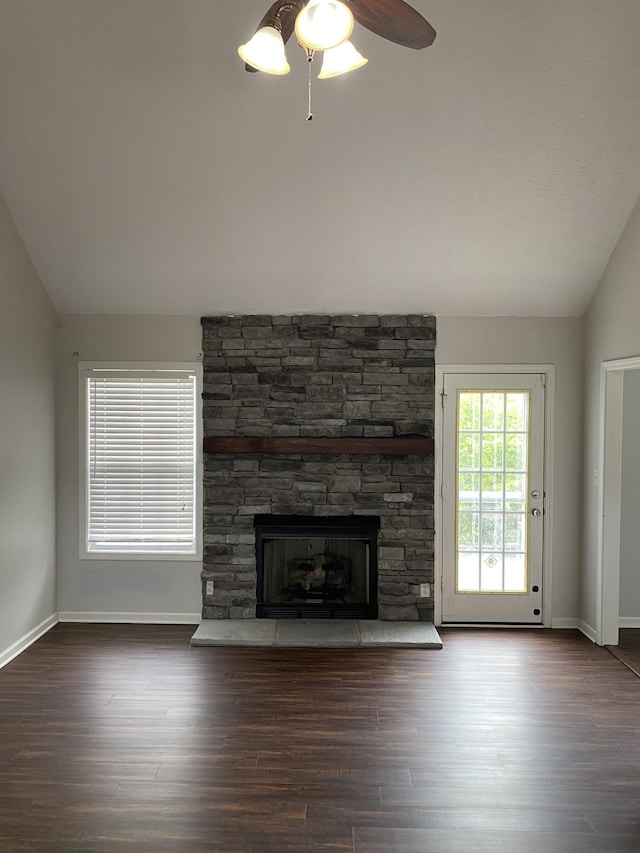 unfurnished living room featuring dark hardwood / wood-style flooring, a stone fireplace, ceiling fan, and lofted ceiling