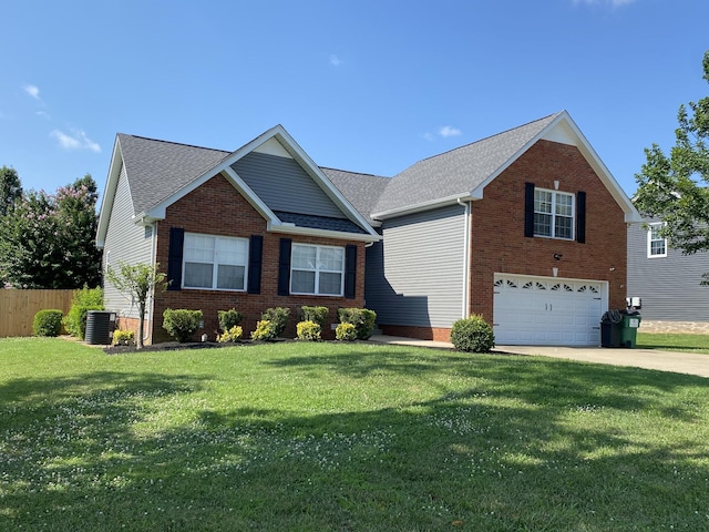 view of front of home with a garage, a front yard, and central AC