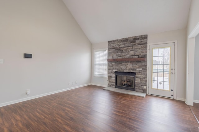 unfurnished living room featuring high vaulted ceiling, a healthy amount of sunlight, dark wood-type flooring, and a fireplace