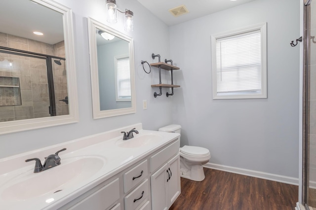 bathroom featuring hardwood / wood-style flooring, vanity, an enclosed shower, and toilet