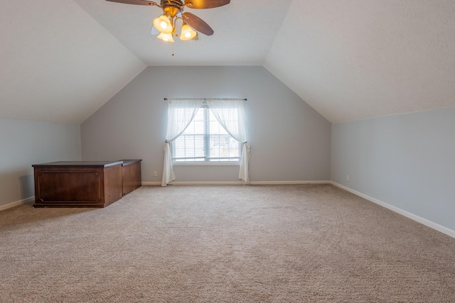 additional living space with vaulted ceiling, light colored carpet, and ceiling fan