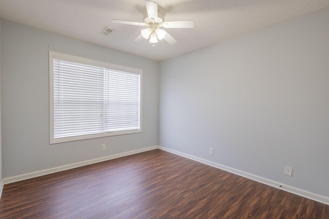 spare room with dark hardwood / wood-style flooring and ceiling fan