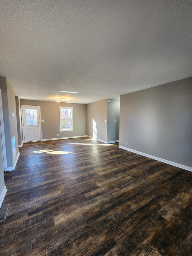 spare room with dark hardwood / wood-style flooring and a textured ceiling