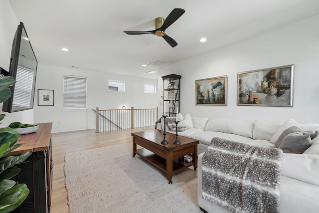 living room with light hardwood / wood-style flooring and ceiling fan