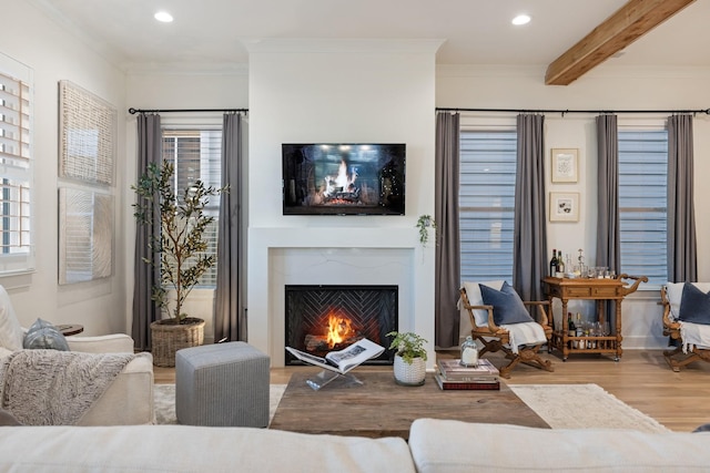 living room featuring a high end fireplace, crown molding, beamed ceiling, and hardwood / wood-style flooring