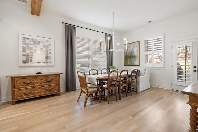 dining room with a wealth of natural light, beamed ceiling, and light hardwood / wood-style floors