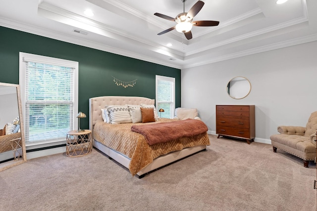 carpeted bedroom with a tray ceiling, ceiling fan, and ornamental molding