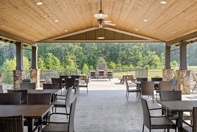 view of patio with ceiling fan and an outdoor stone fireplace