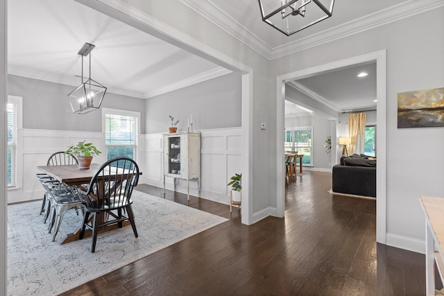 dining space with dark hardwood / wood-style flooring, a notable chandelier, and ornamental molding