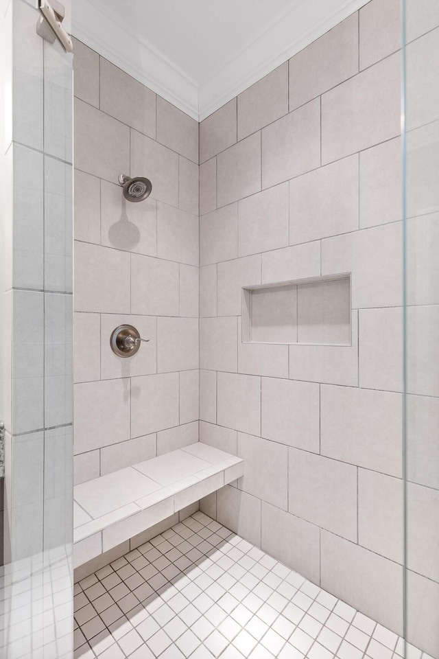 bathroom with a tile shower and ornamental molding