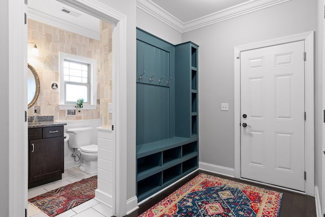 bathroom with tile patterned floors, toilet, vanity, and ornamental molding