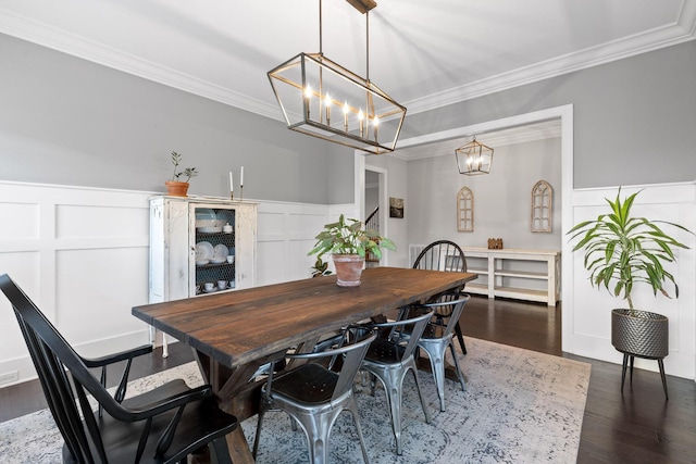 dining area featuring a chandelier, dark hardwood / wood-style floors, and crown molding