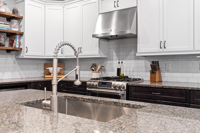 kitchen with white cabinetry, decorative backsplash, extractor fan, and light stone counters