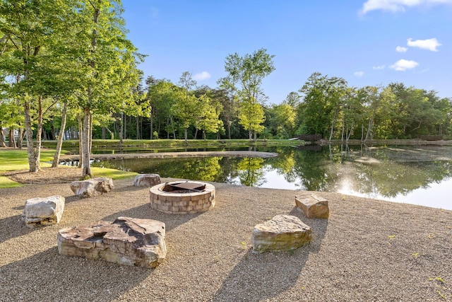 exterior space featuring a water view and a fire pit