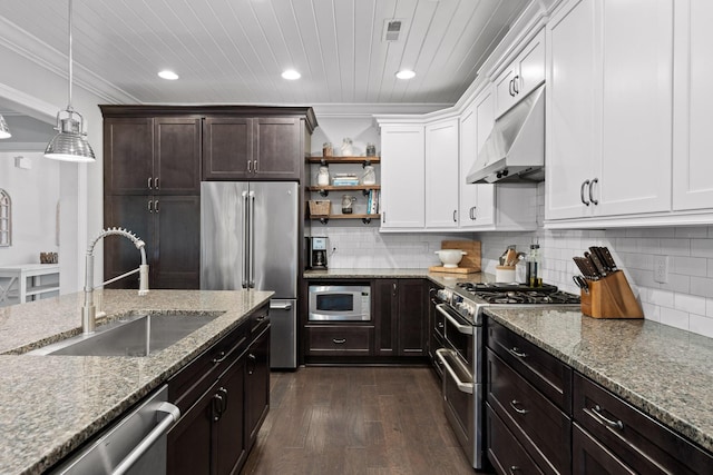 kitchen with sink, hanging light fixtures, extractor fan, high quality appliances, and white cabinets