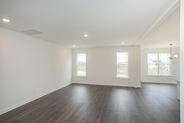 empty room with an inviting chandelier and dark hardwood / wood-style flooring