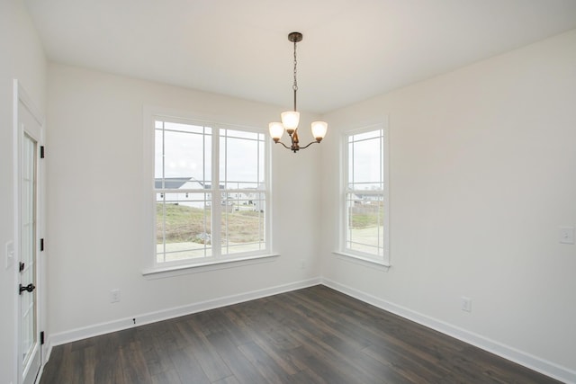 empty room with an inviting chandelier and dark hardwood / wood-style flooring