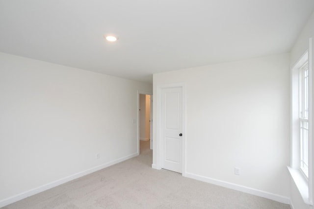 empty room featuring plenty of natural light and light carpet