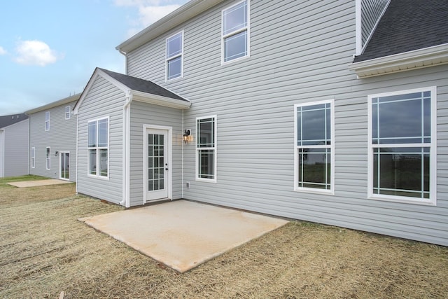 back of house with a patio area and a lawn