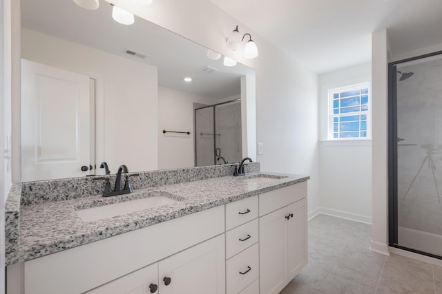 bathroom with tile patterned flooring, vanity, and a shower with door