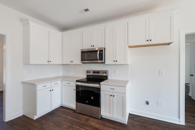 kitchen with decorative backsplash, white cabinets, dark hardwood / wood-style floors, and appliances with stainless steel finishes