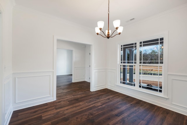 unfurnished dining area featuring crown molding, dark wood-type flooring, and an inviting chandelier