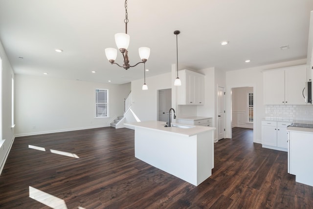 kitchen featuring white cabinets, decorative light fixtures, and sink