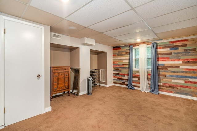 basement with a paneled ceiling and carpet floors