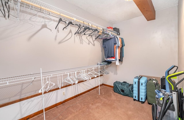 spacious closet featuring carpet and beamed ceiling