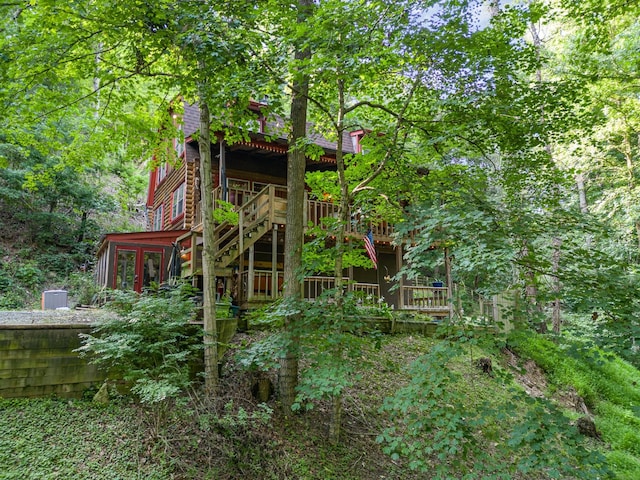 view of playground featuring a wooden deck and a sunroom