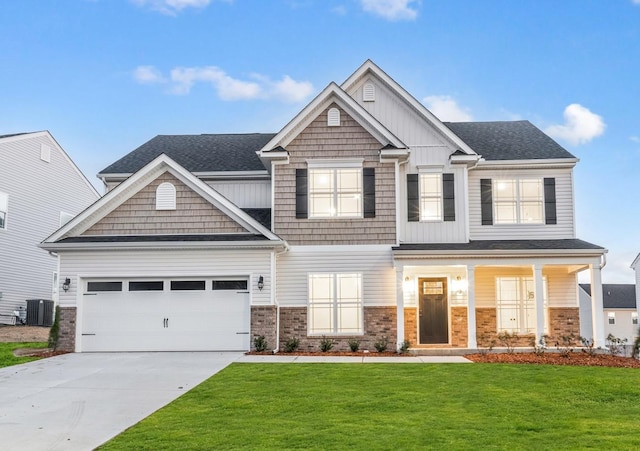 craftsman-style house with a porch, a garage, a front yard, and central AC