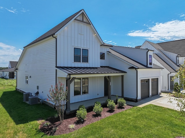 modern inspired farmhouse with a porch, a garage, a front lawn, and central air condition unit