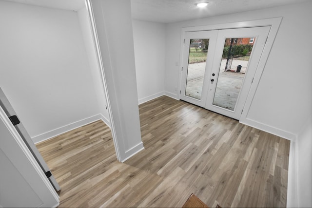 interior space with french doors and light hardwood / wood-style floors