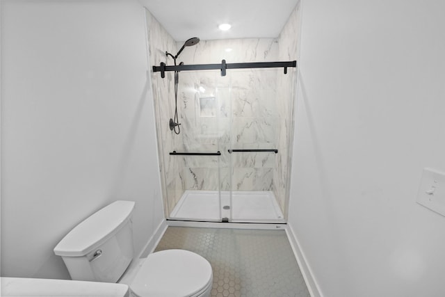 bathroom featuring toilet and a shower with door