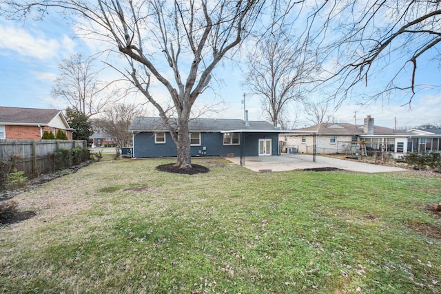 rear view of house featuring a lawn and a patio