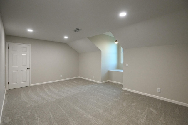 additional living space featuring carpet flooring and lofted ceiling