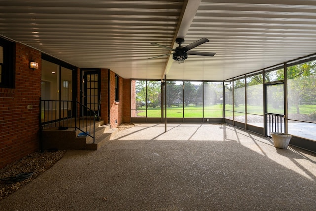 unfurnished sunroom featuring ceiling fan