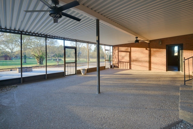 unfurnished sunroom featuring beam ceiling and ceiling fan