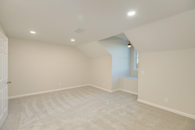 additional living space with light colored carpet and lofted ceiling