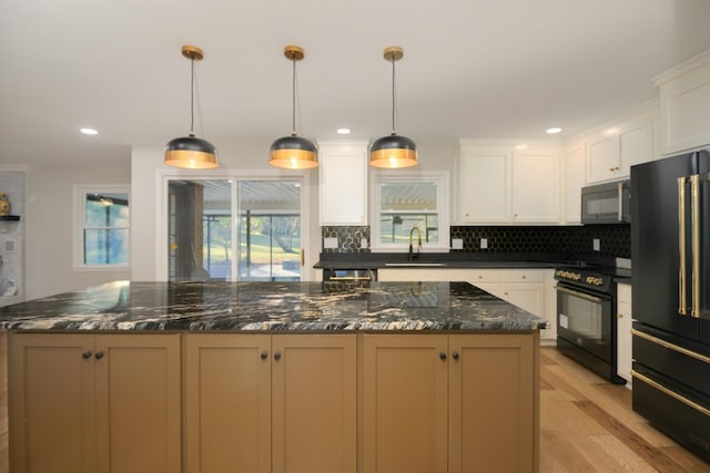 kitchen featuring white cabinetry, sink, hanging light fixtures, high end refrigerator, and black electric range