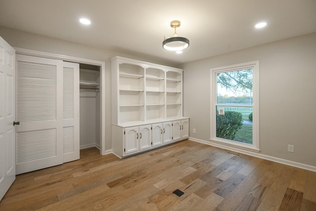 unfurnished bedroom with light hardwood / wood-style flooring and a closet