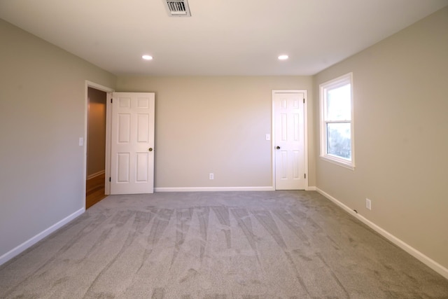 unfurnished room featuring light colored carpet