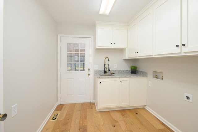 laundry room featuring sink, cabinets, electric dryer hookup, hookup for a washing machine, and light hardwood / wood-style floors