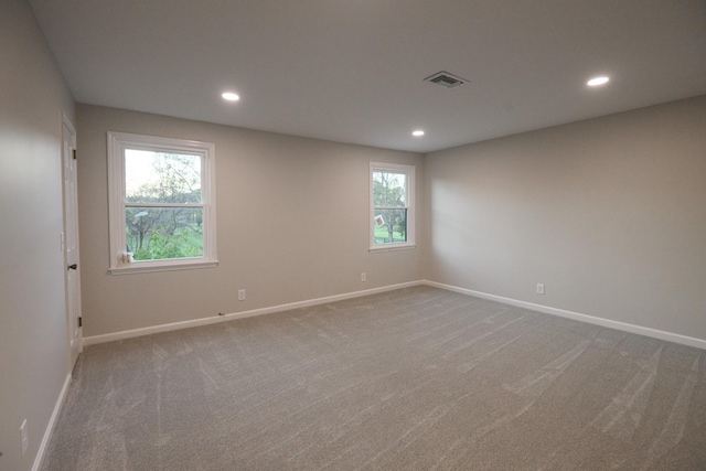 carpeted spare room featuring plenty of natural light