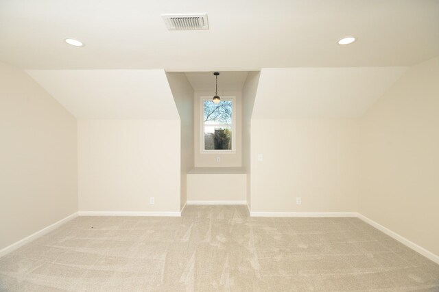 additional living space with light carpet and vaulted ceiling