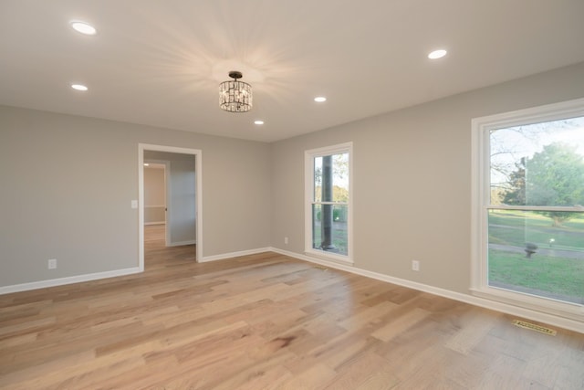 unfurnished room featuring light hardwood / wood-style flooring and a chandelier