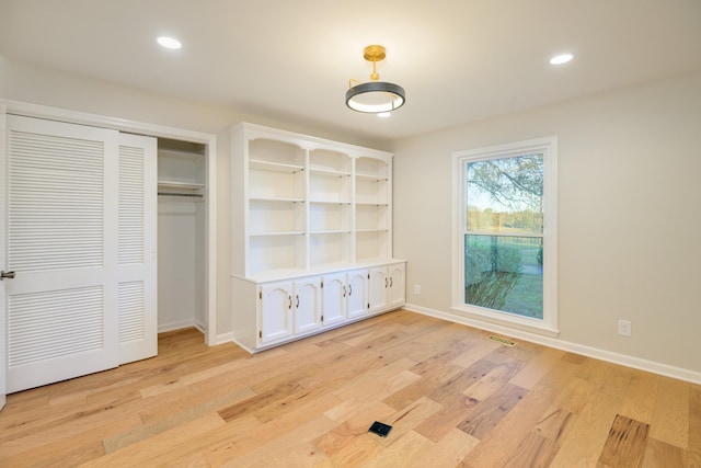 unfurnished bedroom featuring light hardwood / wood-style floors and a closet