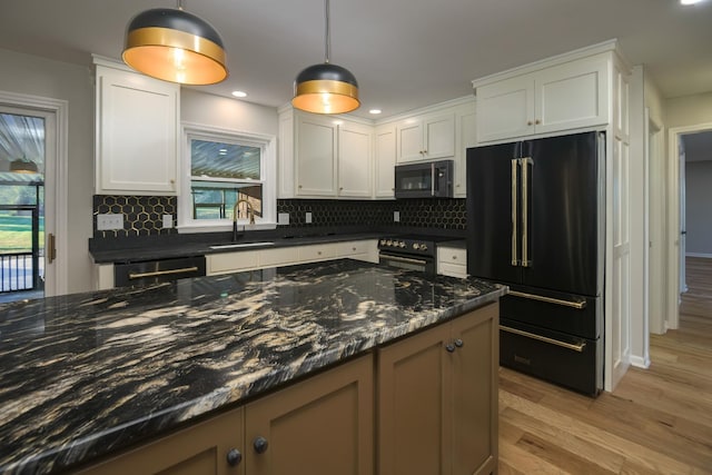 kitchen featuring black appliances, sink, hanging light fixtures, dark stone countertops, and white cabinetry