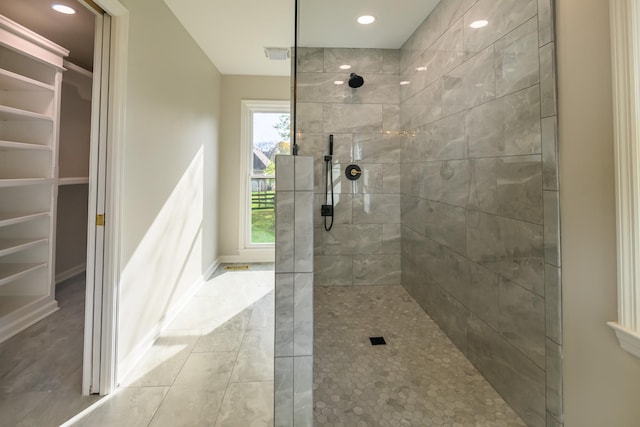 bathroom with tile patterned flooring and a tile shower